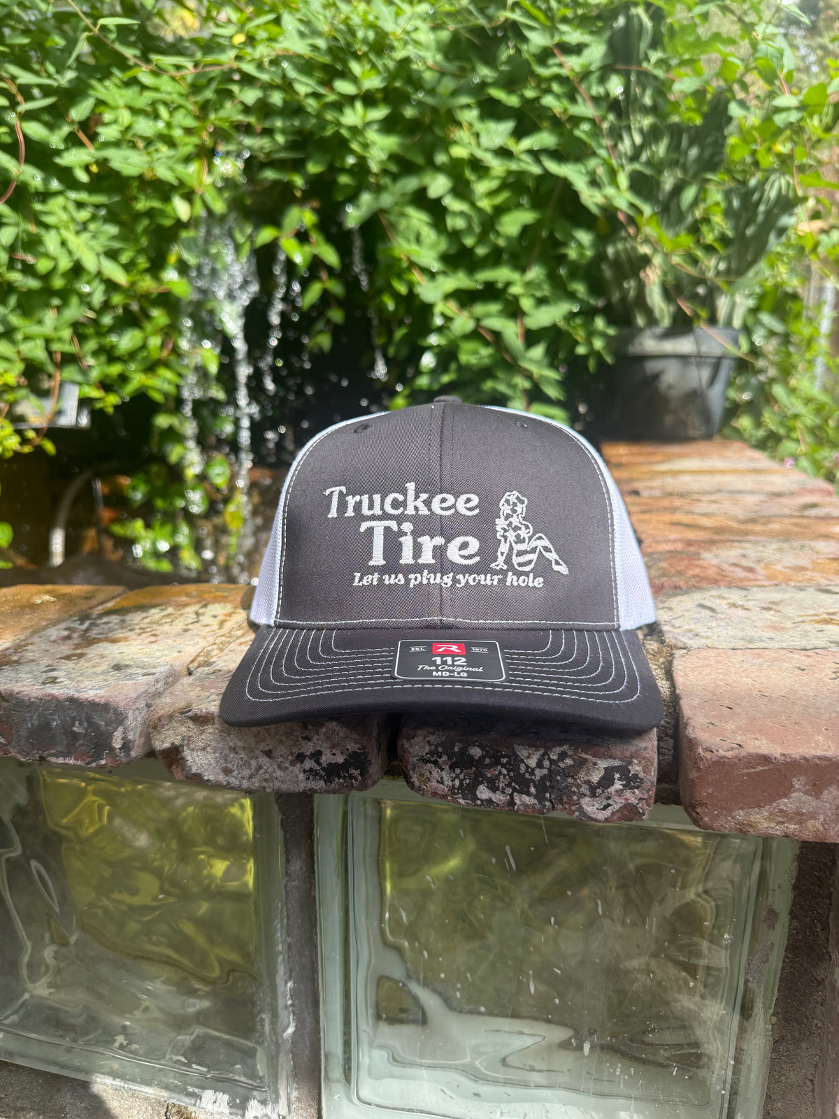 Black and white Richardson 112 trucker hat with Truckee Tire logo embroidered in white
