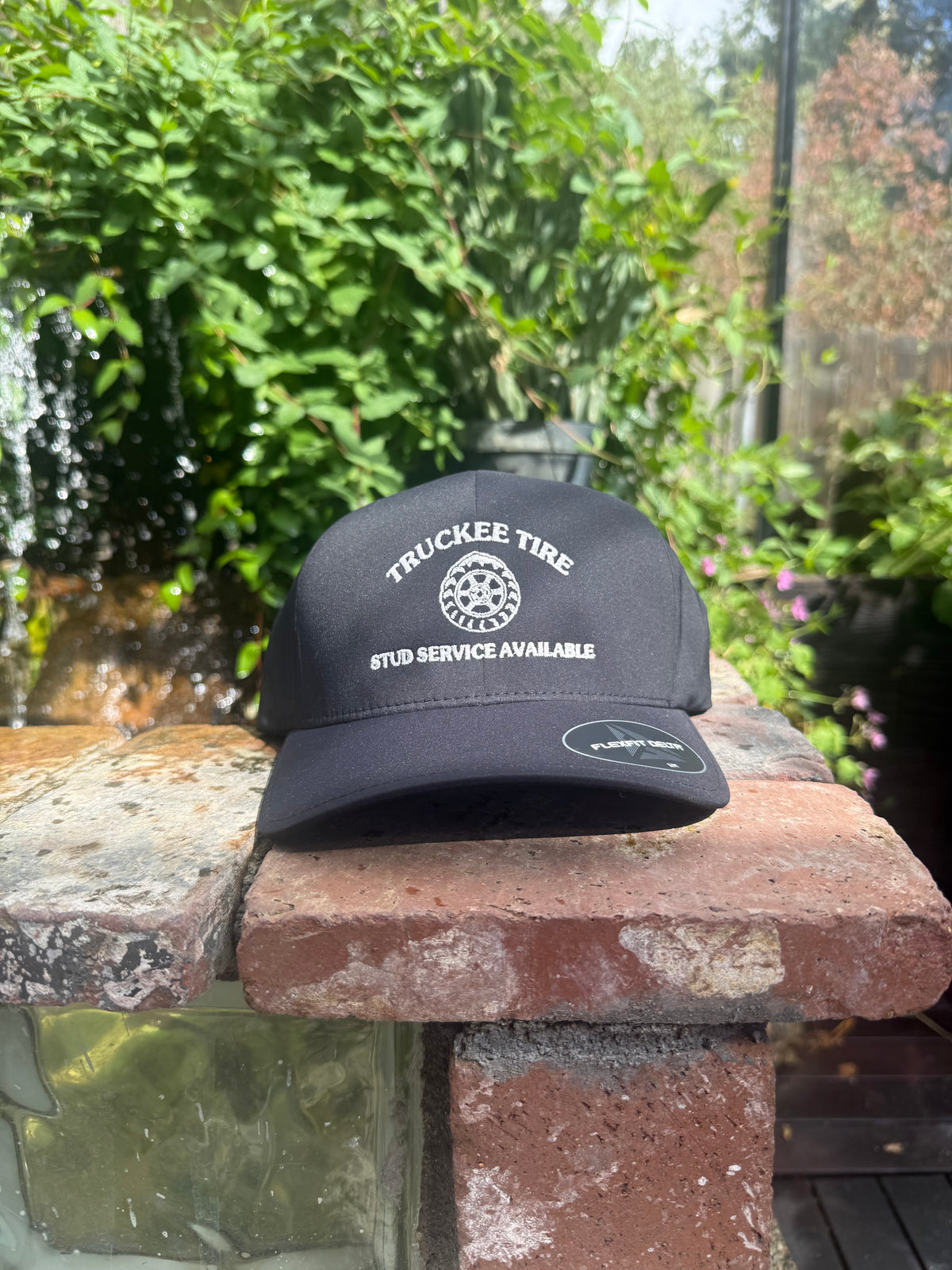 Black Flexfit Delta hat with Truckee Tire studded-tire logo embroidered in white