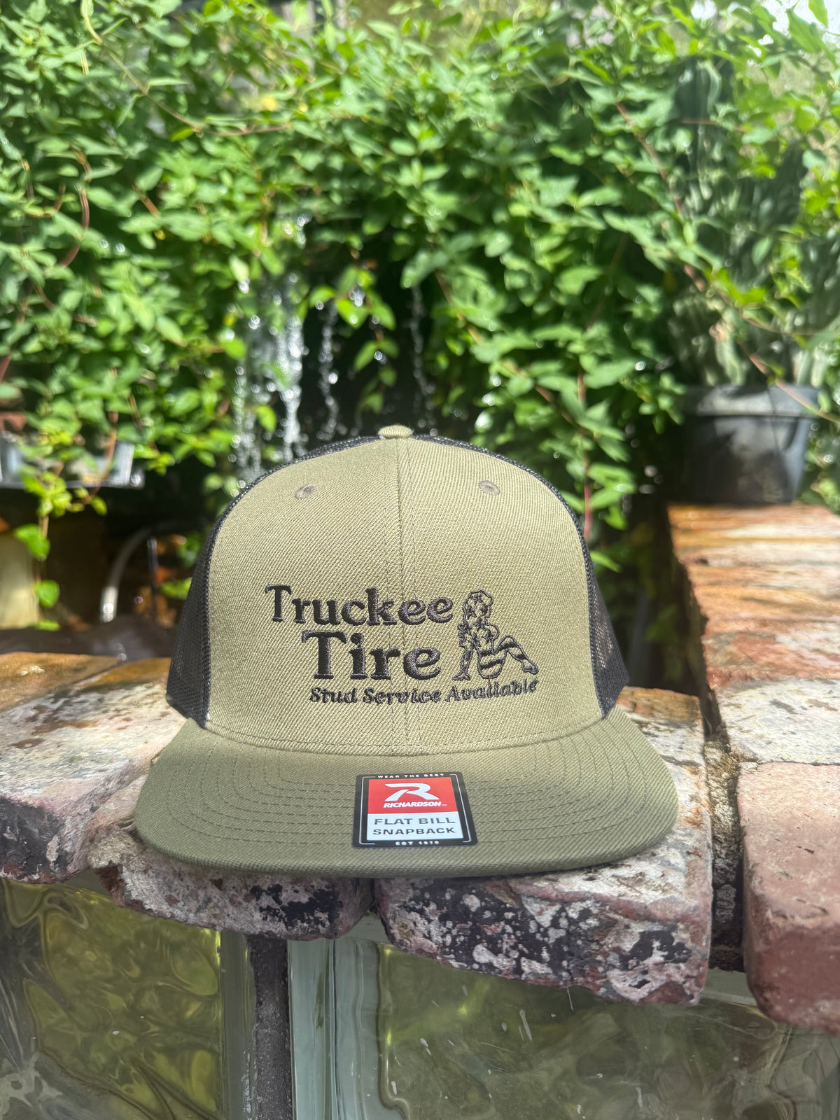 Loden and black Richardson flat-bill trucker hat with Truckee Tire logo embroidered in black